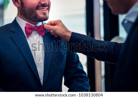 Preparing an elegant man with a red poppy and a blue suit Royalty-Free Stock Photo #1038130804