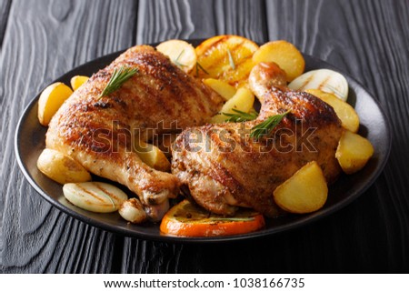 Hot fried chicken legs with grilled oranges, lemon, onion, garlic and potatoes close-up on a plate on a table. horizontal
 Royalty-Free Stock Photo #1038166735