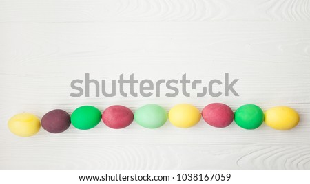 Colorful Easter eggs on white wooden background.