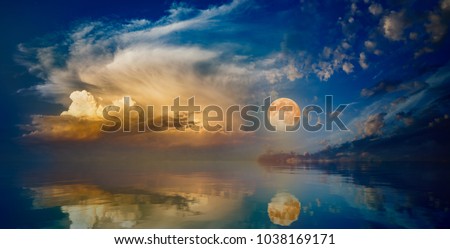 Full moon rising above serene sea in sunset sky. Elements of this image furnished by NASA Royalty-Free Stock Photo #1038169171