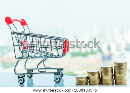 Shopping cart or Supermarket trolley stay with the stack of coins on white background, For business and finance background.