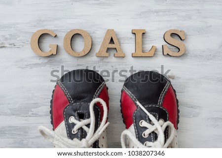 Sneakers on light surface in front of the word goals