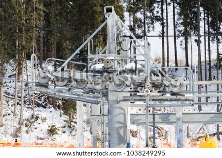 Close-up view of the ski lift mechanism with metallic hawser and rotating tackles