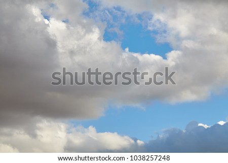 Dark rain clouds covering blue sky
