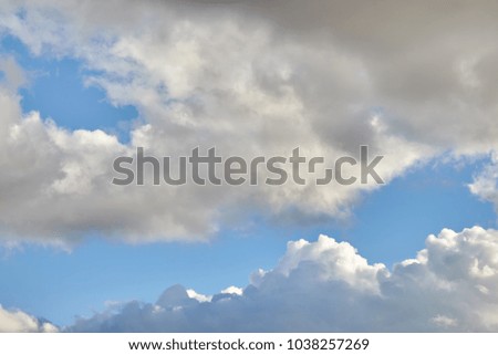 Dark rain clouds covering blue sky