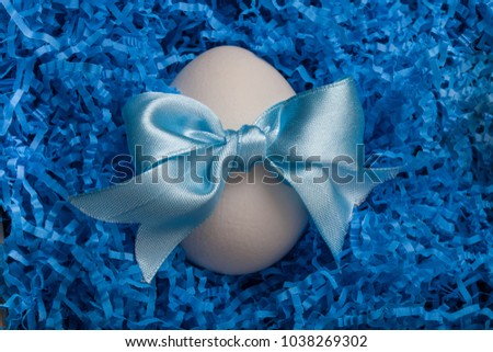Horizontal picture of Decorated easter eggs in   blue straw