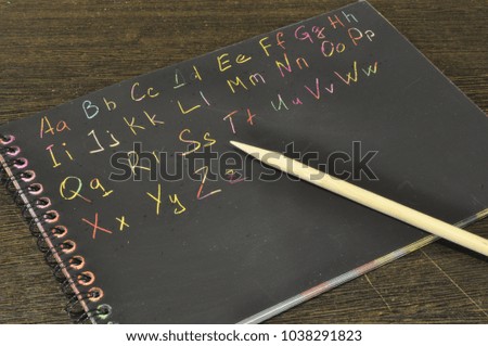 English alphabet handwritten. on black background. colour photo