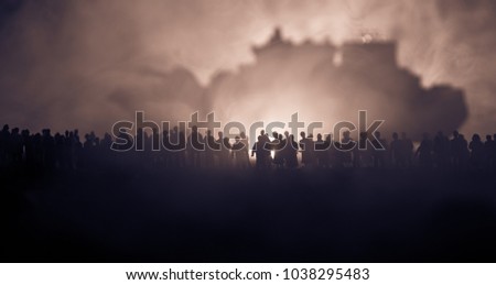 Silhouettes of a crowd standing at blurred military war ship on foggy background. Selective focus. Passengers try to escape. Protest of people
