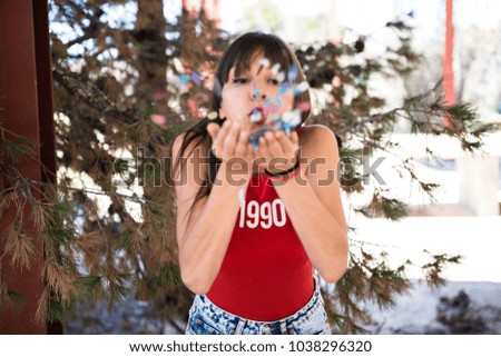 Beautiful young girl playing with confetti