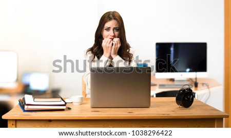 Frightened business woman working with her laptop in the office