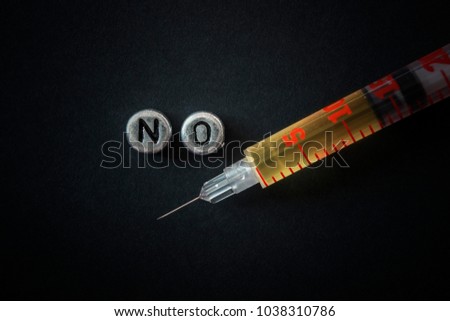 syringe with liquid on a dark background, macro, letters are laid out no