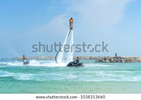 Father and his daughter posing at new flyboard at tropical beach. Positive human emotions, feelings, joy. Funny cute child making vacations and enjoying summer.