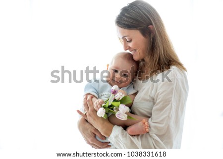 Cute baby boy,  holding bouquet of fresh tulips for mom. Happy Mother's Day