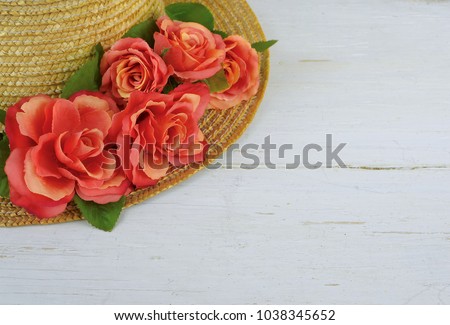 Closeup of a straw bonnet decorated with multiple silk roses on a white washed wooden background with copy space. Good for spring, summer, wedding or Kentucky Derby. Royalty-Free Stock Photo #1038345652