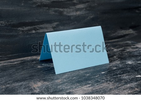 Blue blank card on table. Dark background