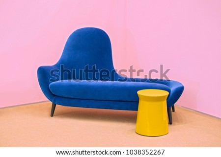 Navy blue sofa on a pink background, laconic interior. Royalty-Free Stock Photo #1038352267
