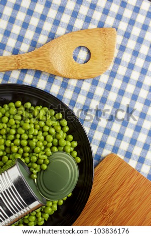 Directly above photograph of green peas on a black plate.