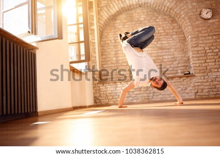 Young man break-dancer doing handstand on hands