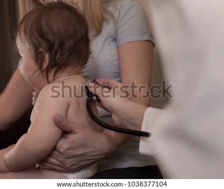 Doctor using stethoscope to examining little baby.