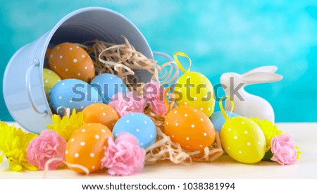 Happy Easter ornaments, eggs and spring flowers on a blue and white background.