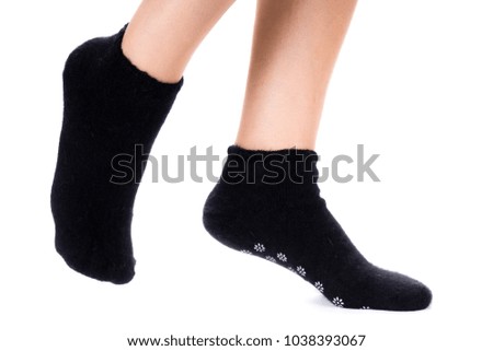 Side view of beautiful human foot dressed in new nice and soft natural cotton fabric blank black sock isolated on a white background. Wearing and sport clothes concept. Detailed closeup studio shot.