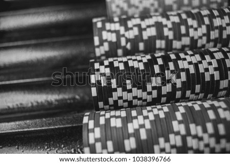 Casino / poker chips colorful gaming pieces lie on the game table in the stack. Background for gambling / casino, business, poker. many colorful casino chips. black and white photography. Soft focus