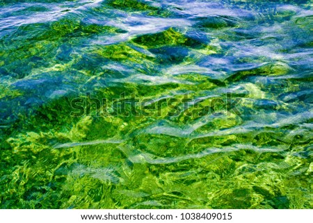 Turquoise and green ripple reflections in the water