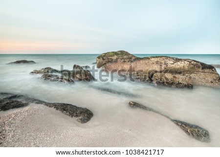 Long exposure shot. Sea scape with stone beach at sunset, Motion blur, slow shutter speed.