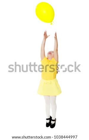 A lovely little round-faced blonde girl, with very long beautiful hair, in short skirts and yellow jerseys.She catches a balloon.Isolated on white background.
