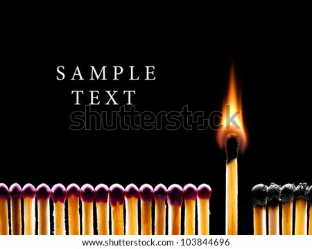 Many red matches on a black background (one match burns). Royalty-Free Stock Photo #103844696