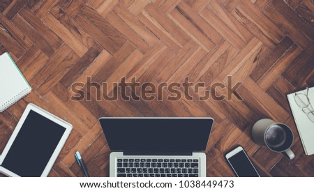 Top view smartphone and laptop with coffee cup, Airplane, Photos and Credit card on  wooden background.