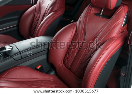 Modern Luxury car inside. Interior of prestige modern car. Comfortable leather red seats. Red perforated leather cockpit with isolated Black background. Modern car interior details Royalty-Free Stock Photo #1038515677