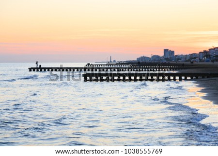 Beach landscape at dawn. Piers perspective view with people. Jesolo beach view, Italian panorama