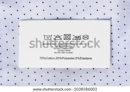 Content and care clothes label on pastel blue textile background