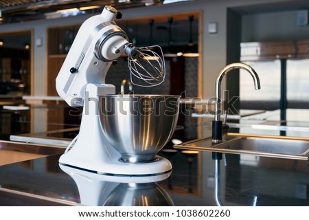 A beautiful white mixer with a metal cup stands in the modern kitchen Royalty-Free Stock Photo #1038602260