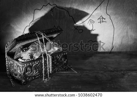 An antique wooden lacquered casket with pieces of glass and metal chains. Black and white photography.