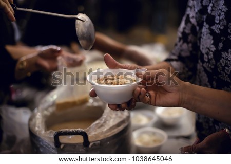 Feeding the poor to hands of a beggar. Poverty concept Royalty-Free Stock Photo #1038645046