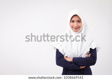 confident happy smiling muslim business woman; studio portrait of islamic business woman with hijab, head scarf; asian businesswoman, female business person crossing arms; asian girl adult model