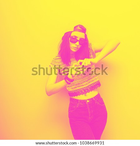 Girl shows heart by fingers in fashion clothing. yellow and pink monochrome