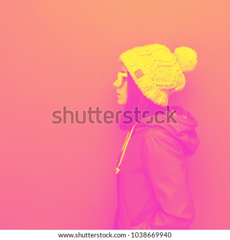 the girl in the hat stands sideways. yellow and pink double colors