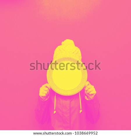 girl holding an empty plate in front of her face. yellow and pink double color effect 
