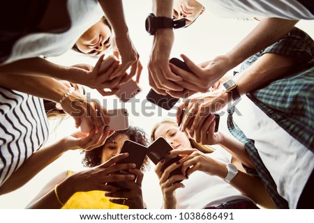 Young adults using smartphones in a circle social media and connection concept Royalty-Free Stock Photo #1038686491
