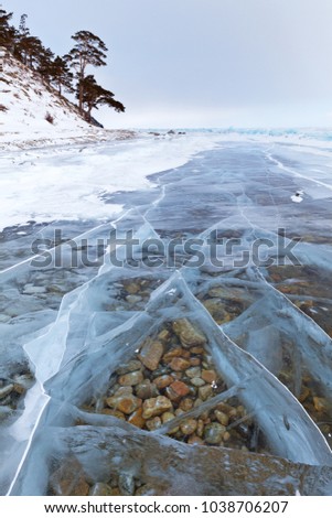 Beautiful transparent blu ice with cracks on Baikal Lake in winter cold day