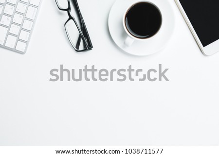 Top view of white office desktop with cellphone, keyboard, glasses and coffee cup. Mock up 