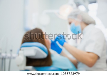 Defocused, blurred image of dentist with patient at clinic office. Stomatologist making tooth treatment at hospital.