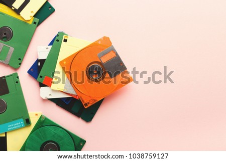 Old floppy disks isolated on pink background. Border of magnetic retro storage devices, cutout of colorful diskettes, copy space, flat lay, top view Royalty-Free Stock Photo #1038759127