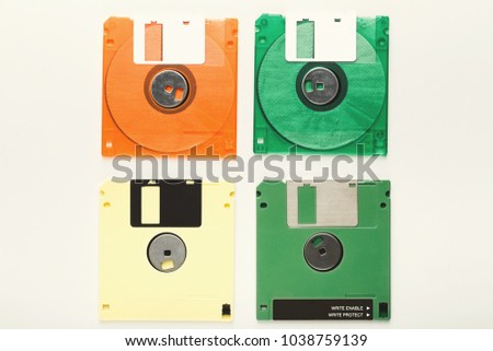 Old floppy disks isolated on white background. Top view of magnetic retro storage devices, cutout of colorful diskettes, copy space, flat lay