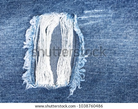 Old denim jeans torn at the knee close up. Jeans background Royalty-Free Stock Photo #1038760486