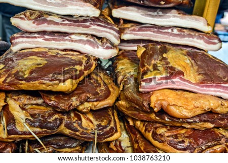Homemade bacon on the table exposed for sale.