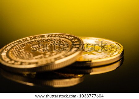 Studio shot of a bitcoin physical golden coin on a dark background. Bitcoin is a blockchain crypto currency